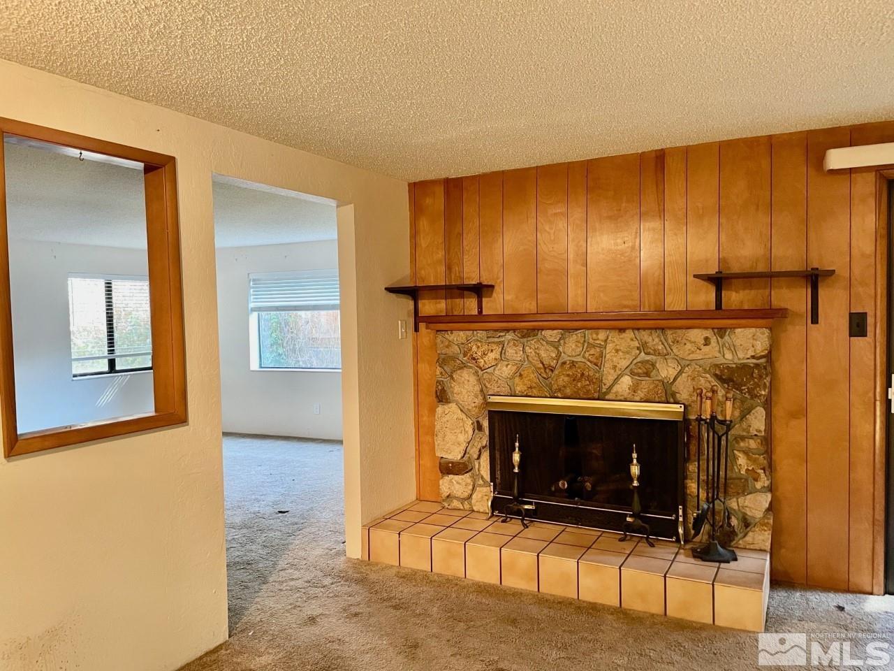3280 Idlewild Drive Reno, NV 89509 - Photo 5 of 22 a living room with furniture a fireplace and a table