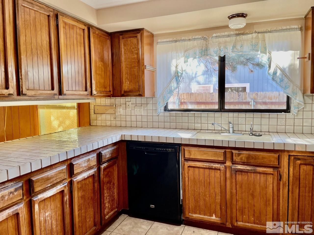 3280 Idlewild Drive Reno, NV 89509 - Photo 6 of 22 a kitchen with wooden cabinets and a sink