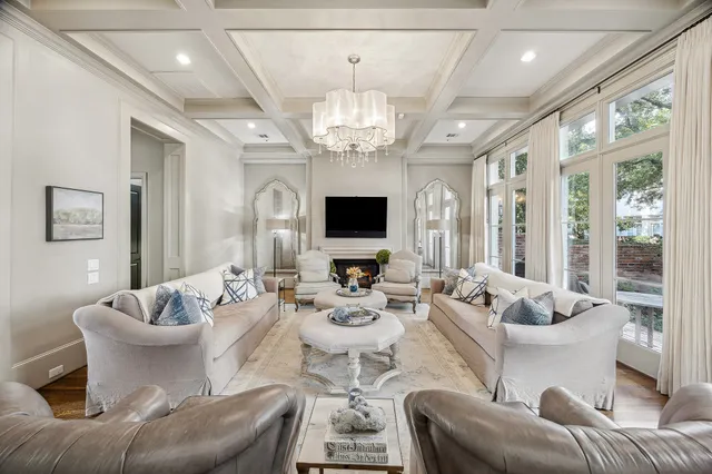 a living room with furniture chandelier and a large window
