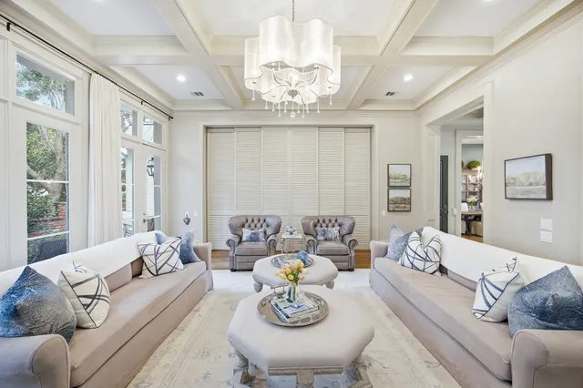 a living room with furniture chandelier and a table