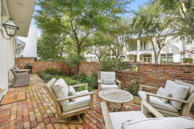 a view of a patio with couches table and chairs and potted plants