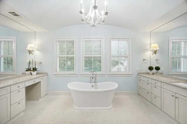 a spacious bathroom with a double vanity sink a large mirror and a bathtub