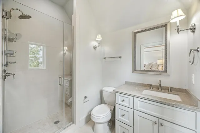 a bathroom with a granite countertop sink toilet and shower