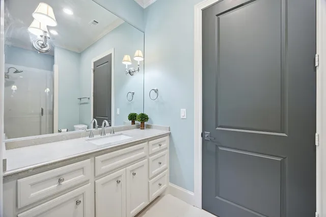 a spacious bathroom with a granite countertop sink a mirror and a shower