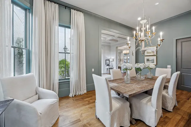 a dining room with furniture a chandelier and wooden floor