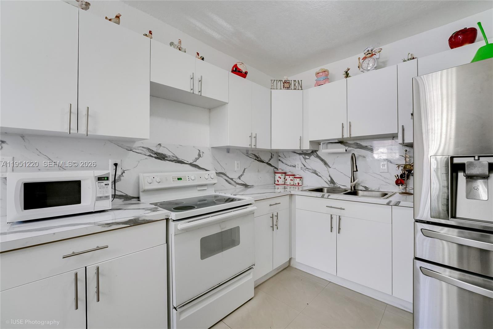 860 Southeast 7th Avenue Hialeah, FL 33010 - Photo 8 of 16 a kitchen with stainless steel appliances granite countertop a sink a stove a refrigerator and white cabinets