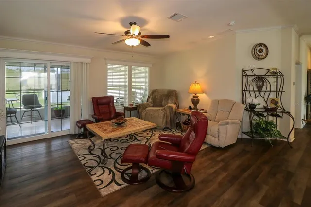 a living room with furniture a table and wooden floor