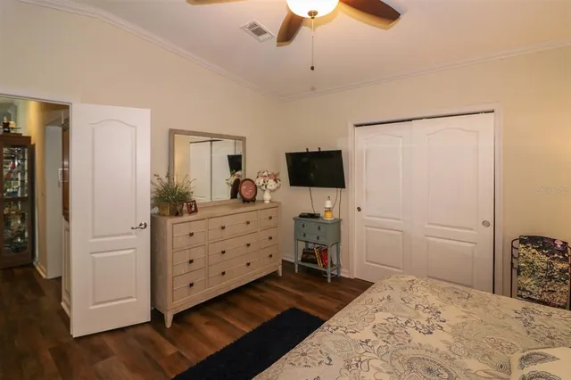 a room with a bed and a flat tv screen on dresser