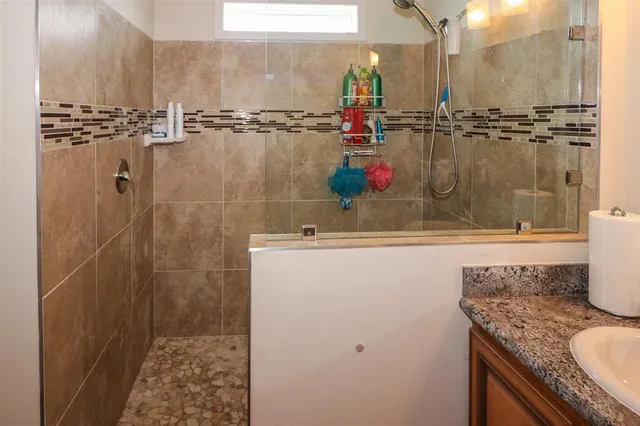 a bathroom with a granite countertop sink and a mirror