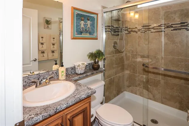 a bathroom with a granite countertop sink toilet a mirror a shower and a bathtub