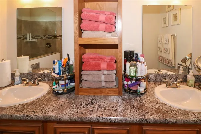 a bathroom with a sink double vanity and a granite counter top