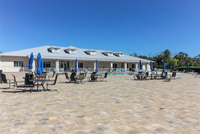 a view of a white house with a swimming pool and sitting area