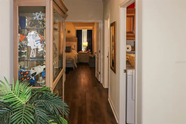 a view of a hallway with wooden floor and a living room