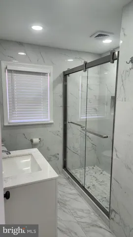 a bathroom with a shower sink and mirror