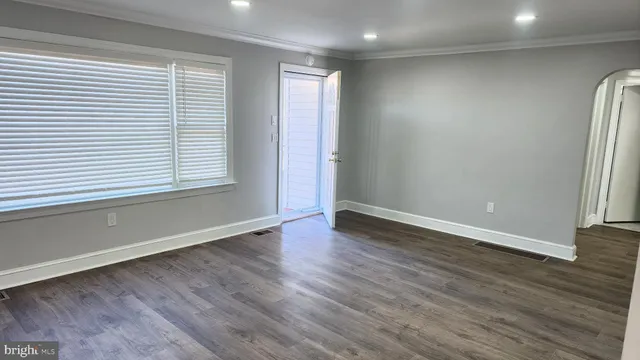an empty room with wooden floor and a window