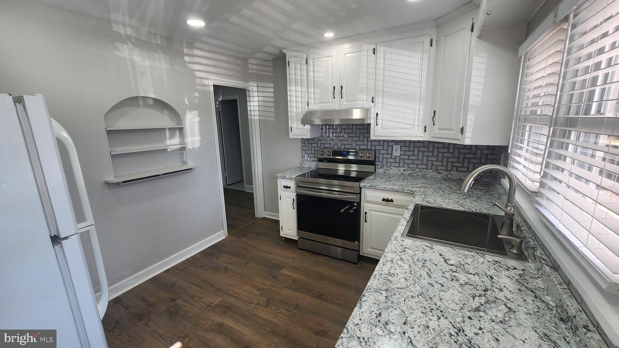 706 East Division Street Dover, DE 19901 - Photo 7 of 20 a kitchen with granite countertop a refrigerator stove and sink