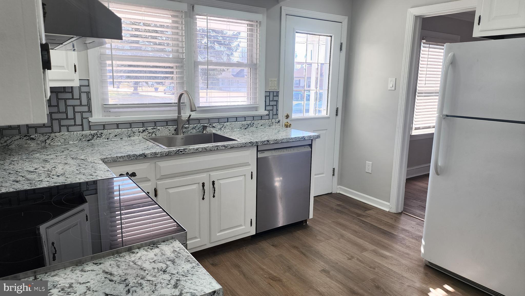 706 East Division Street Dover, DE 19901 - Photo 8 of 20 a kitchen with granite countertop a sink and a refrigerator