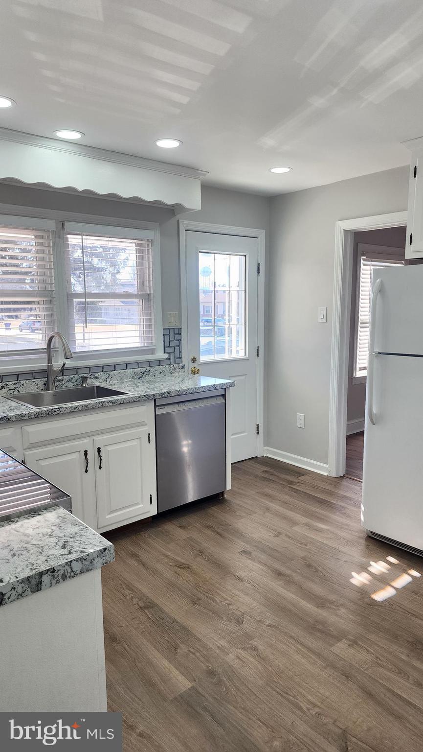 706 East Division Street Dover, DE 19901 - Photo 10 of 20 a large kitchen with granite countertop a white stove top oven sink and window