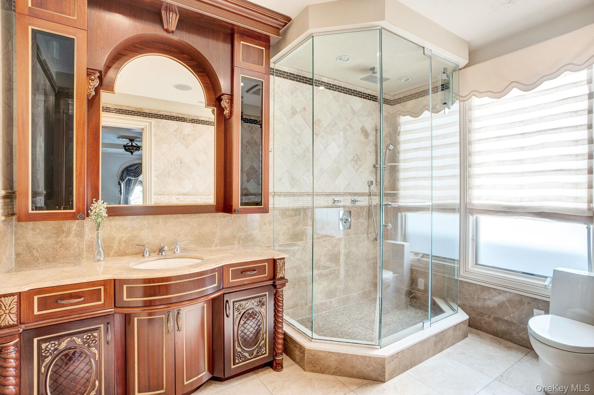 181-30 Tudor Road Queens, NY 11432 - Photo 24 of 46 Bathroom with vanity, light tile patterned floors, tile walls, a shower stall, and tasteful backsplash