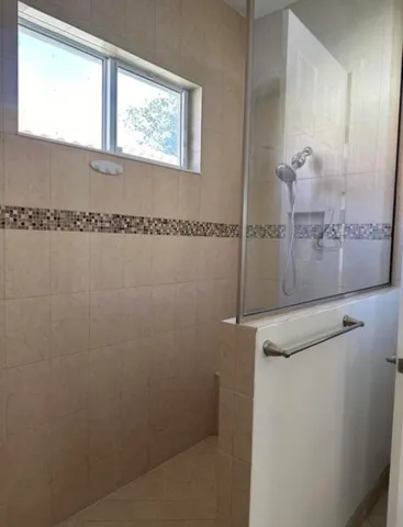 a bathroom with a window and a shower