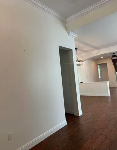 an empty room with wooden floor and stairs