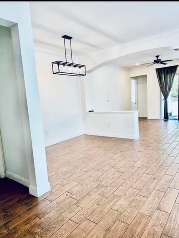a view of empty room with wooden floor