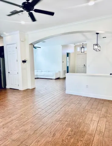 a view of a livingroom with wooden floor and a ceiling fan