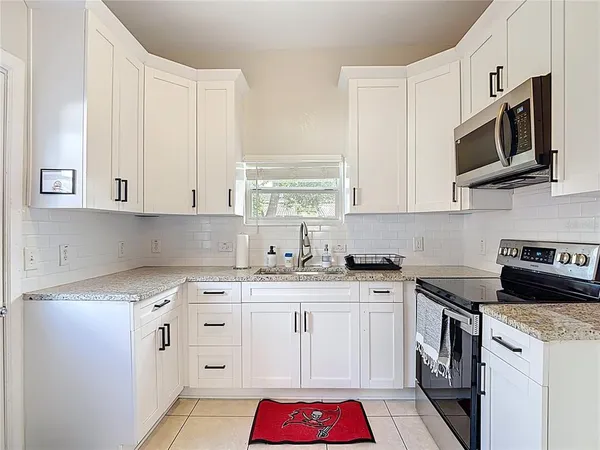 a kitchen with stainless steel appliances granite countertop a sink stove and cabinets
