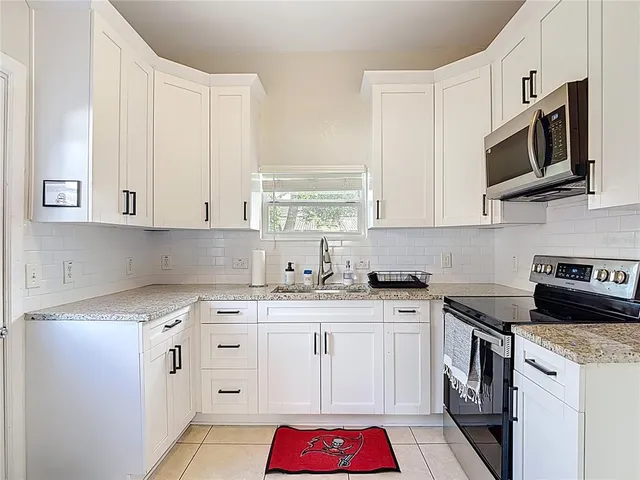 a kitchen with stainless steel appliances granite countertop a sink stove and cabinets