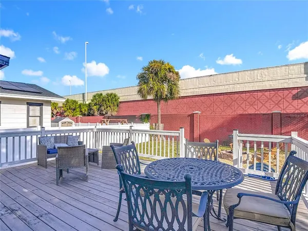 a view of a deck and dining room with wooden floor and fence