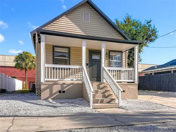 a view of a house with a yard and potted plants