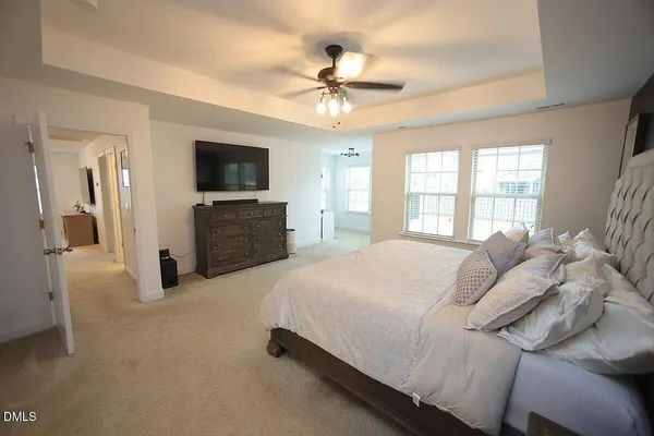 a spacious bedroom with a bed and a flat screen tv