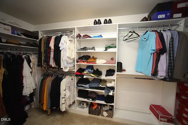 a view of walk in closet with clothes and shoes
