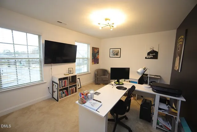 a view of a livingroom with workspace and a window