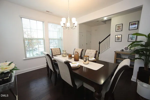 a view of a dining room with furniture a chandelier and wooden floor