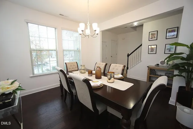 a view of a dining room with furniture a chandelier and wooden floor