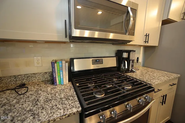 a stove top oven sitting inside of a kitchen