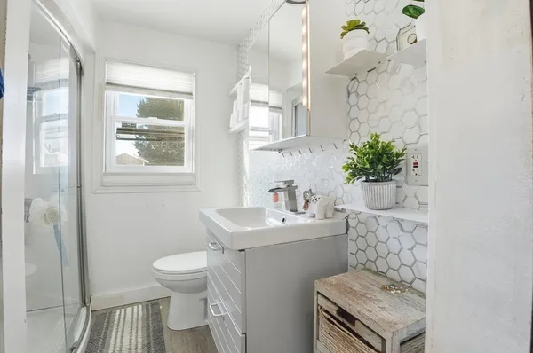 a bathroom with a sink toilet and a mirror