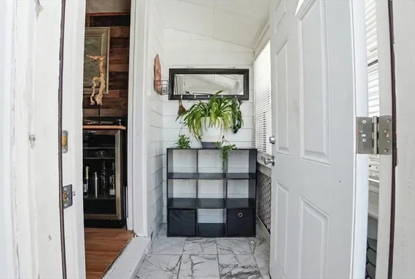 a view of a hallway with wooden floor and windows