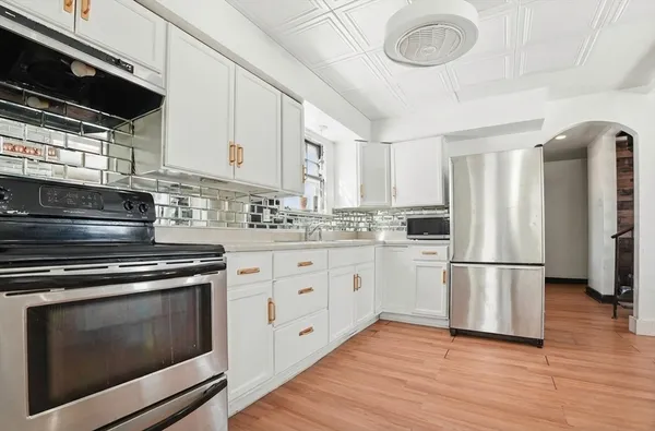 a kitchen with stainless steel appliances a stove a sink and a refrigerator