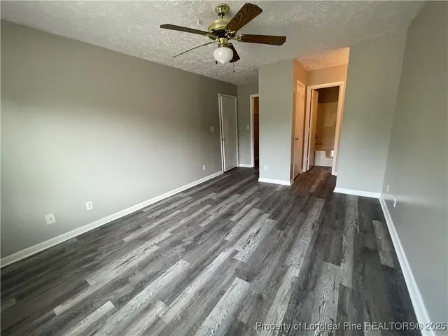 a view of a room with wooden floor and a ceiling fan