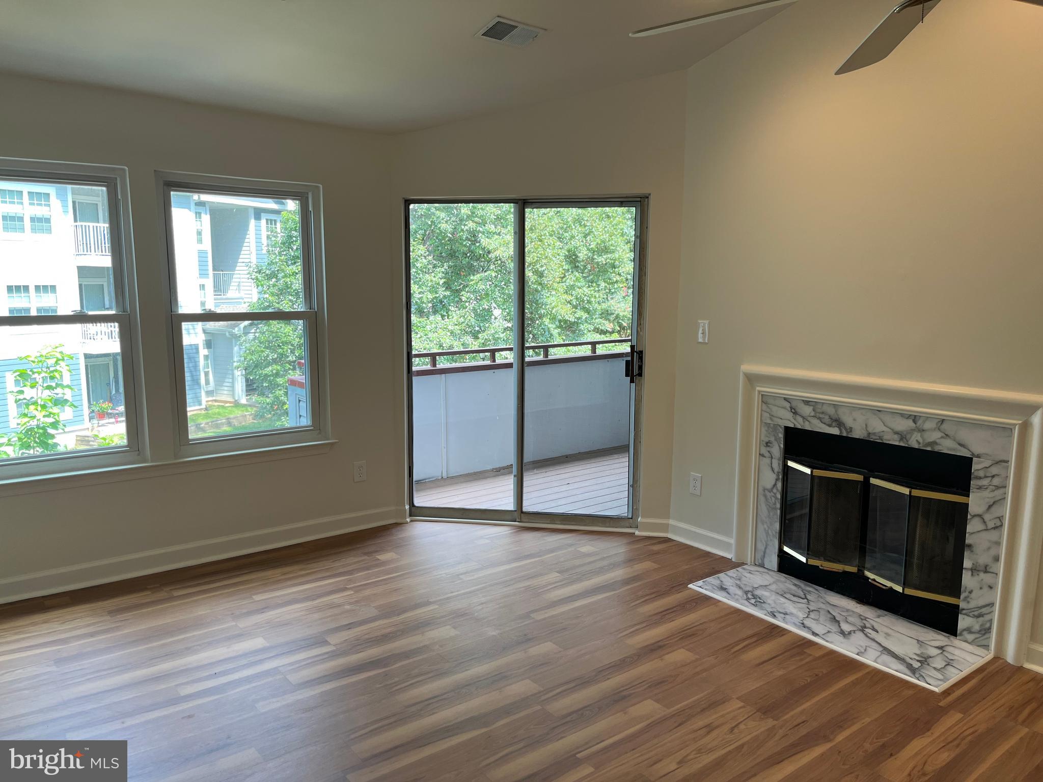 3301 Sir Thomas Drive, Unit 6B41 Silver Spring, MD 20904 - Photo 21 of 54 an empty room with wooden floor fireplace and windows