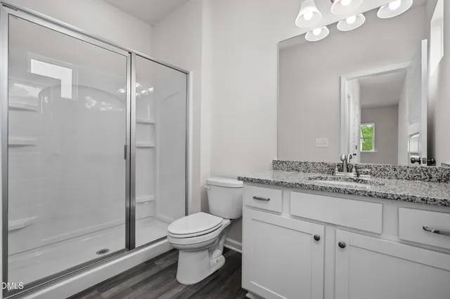 a bathroom with a granite countertop sink a toilet and a mirror