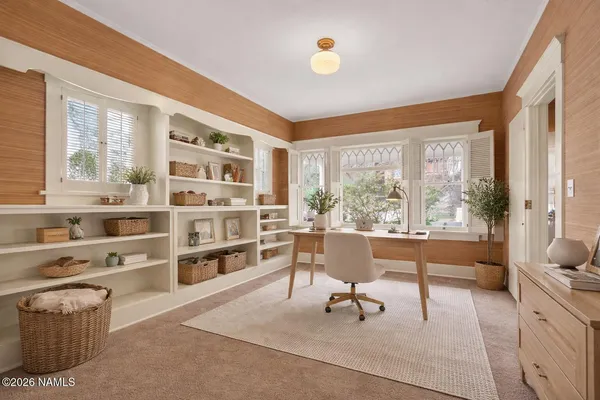 a living room with furniture cabinets and a large window