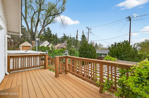 a balcony with wooden floor and outdoor seating
