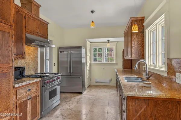 a kitchen with stainless steel appliances granite countertop a stove refrigerator and a sink