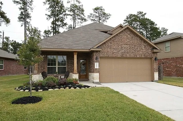 a front view of a house with a garden and yard