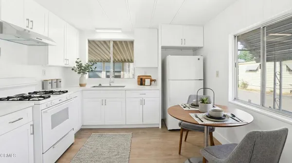 a kitchen with a sink stove and white table top oven