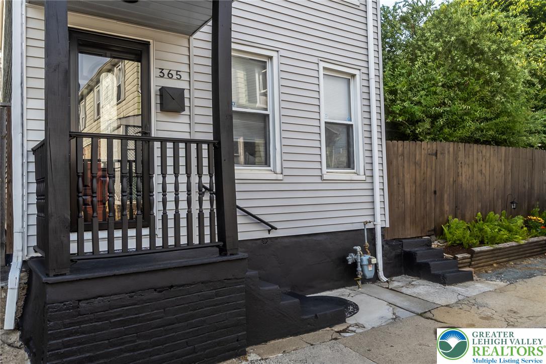 365 Rock Street Easton, PA 18042 - Photo 3 of 50 A classic facade with light siding, a dark porch, and a fenced-in garden awaits new owners.