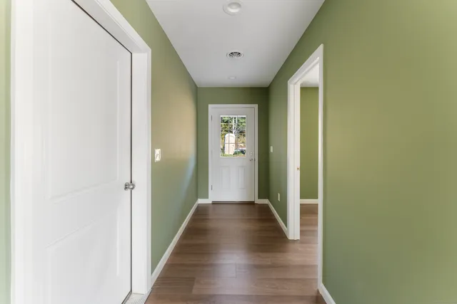 a view of a hallway with wooden floor